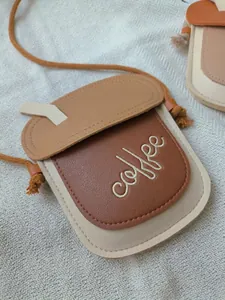 Detail of coffee cup shaped mini bag with embroidery and adjustable rope strap
