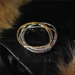 Close-up of stacked 2mm elastic rhinestone bracelets in gold, silver and multicolor tones