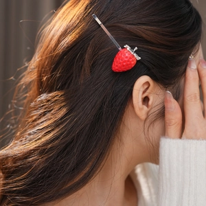 Dettaglio del fermaglio per capelli a fragola in resina rossa con strass su modella