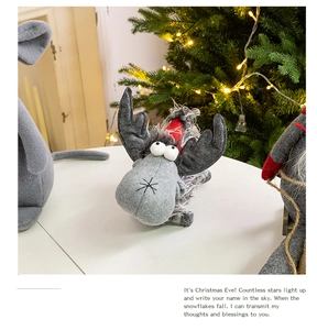 Detailed texture of handmade grey felt reindeer doll with red scarf under Christmas tree light