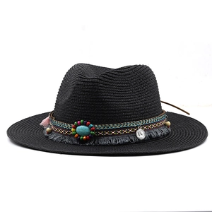 Detail of black straw fedora with bohemian ethnic band, fringe, and turquoise stone