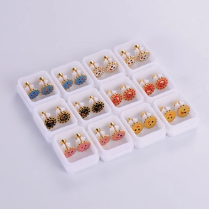 Detail view of 12 pairs of colorful sunflower smile earrings in individual white gift boxes