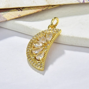 Macro shot of gold crescent moon pendant set with clear cubic zirconia on an O-chain