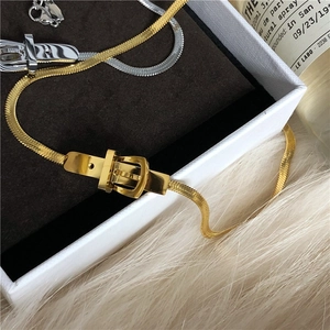 Close-up of gold and silver flat snake chains with unique belt buckle metal clasps