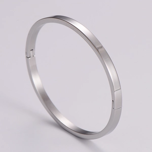Macro view of silver minimalist hinged bracelet with mirror polished finish and buckle
