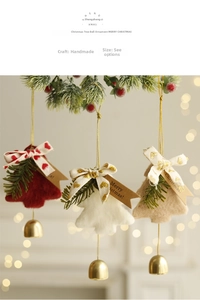 Detail of felt Christmas tree ornaments with golden bells hanging on a festive branch