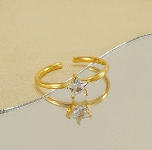 Close-up of gold star-shaped zircon ring reflecting on a champagne mirror surface