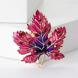 Detail of luxury maple leaf brooch with pink and purple enamel and sparkling crystals