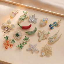 Flat lay of vintage style flower brooches with freshwater pearls and shell inlays
