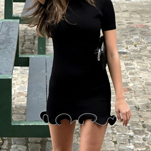 Mini robe noire ajustée avec bordure blanche contrastée et ourlet ondulé à volants