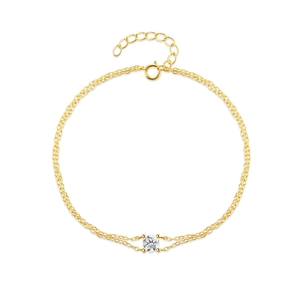 Detailed macro view of a gold double-layer chain bracelet with a four-prong zircon stone