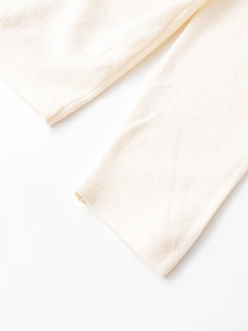 Detailed macro view showing the soft pleated wool texture and stitching of the cream top