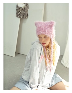 Detail of pink faux fur cat ear hat with soft texture and long earflap ties