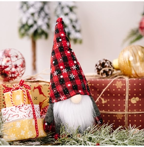 Close-up of a Christmas gnome doll with red and black plaid snowflake hat and white beard