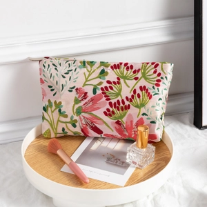Floral print makeup bag with zipper closure on a wooden tray for travel storage
