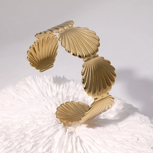 18k gold plated stainless steel open bangle featuring continuous seashell textured designs