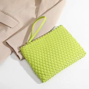 Handmade woven clutch bag in vibrant lime green with a minimalist wrist strap design