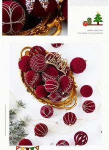 Close-up of burgundy flocked Christmas balls with gold glitter patterns and vintage tray