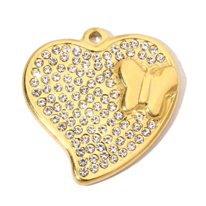 Dettaglio macro del ciondolo a cuore dorato con pavé di cristalli e farfalla 3D