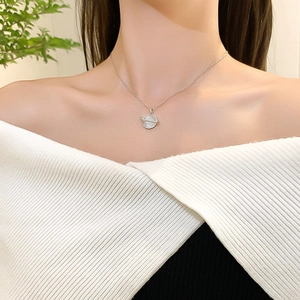 Luxurious planet necklace with cat eye stone and diamonds on a cross chain worn by model