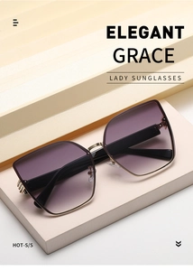 Close-up of elegant oversized cat-eye sunglasses with purple gradient lenses and gold frames