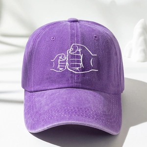 Detailed embroidery of fist bump gesture on purple washed cotton baseball cap