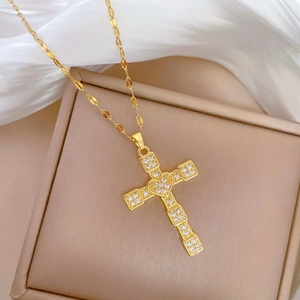 Elegant gold cross heart pendant necklace with rhinestones on white satin display