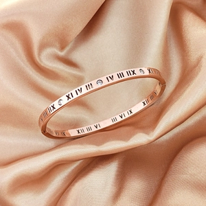 Rose gold Roman numeral bracelet with diamonds on champagne silk background