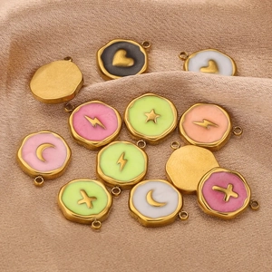 Macro shot of assorted star and lightning bolt enamel charms on champagne silk fabric