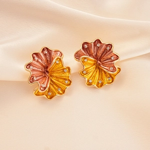 Detailed view of fan-shaped fan-shaped metal earrings with red-yellow enamel and diamonds