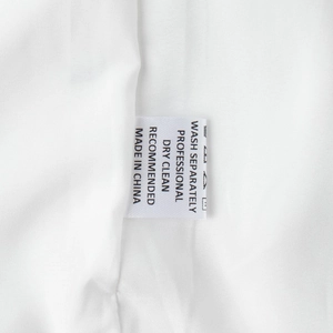 Close-up of the wash care label showing washing instructions on white square neck dress