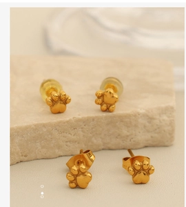 Détail de boucles d'oreilles patte de chat dorées avec fermoirs silicone et métal