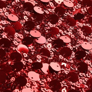 Gros plan sur un tissu à paillettes rouges avec de grands sequins et des reflets brillants