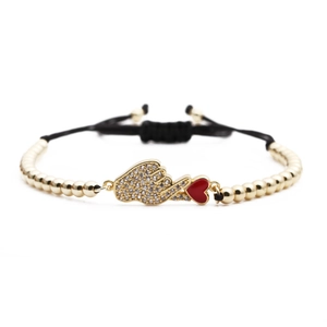 Braided black cord bracelet with gold beads, zircon hand gesture and red heart charms