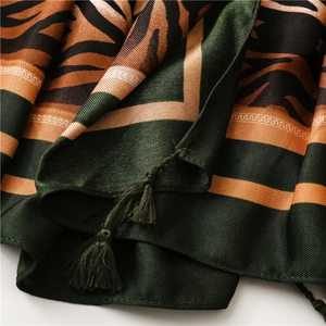 Close-up of zebra stripe pattern silk shawl with vibrant orange and green tassel details
