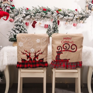Kerststoelhoezen van linnen met geborduurde rendieren en geruite ruches voor decoratie