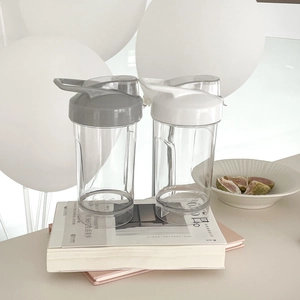 Close-up of clear plastic sport cups in gray and white with convenient carry handles