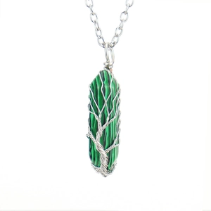 Macro view of green malachite hexagonal pendant with silver tree of life wire wrapping