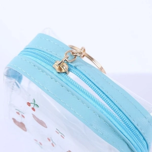 Close-up of golden zipper and metal ring on sky blue cherry print PVC pouch
