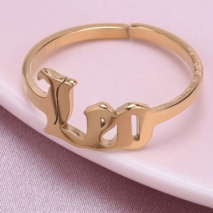 Detailed close-up of golden Leo zodiac ring with gothic lettering on purple satin fabric