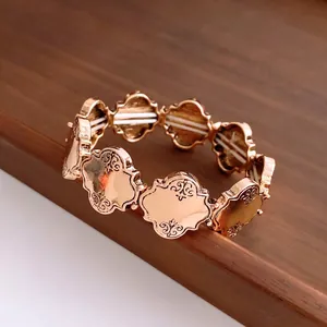 Vintage goldenes elastisches Armband mit gravierten Kleeblättern auf Holzfläche