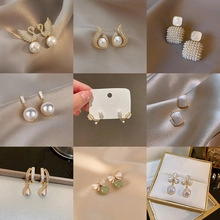 Detailed grid of silver needle pearl earrings with swan and geometric patterns