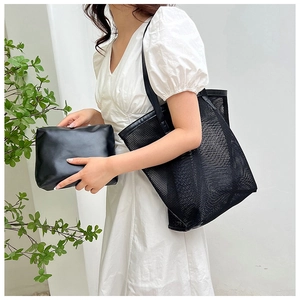 Detail of black mesh beach tote bag with matching inner pouch and leather handles