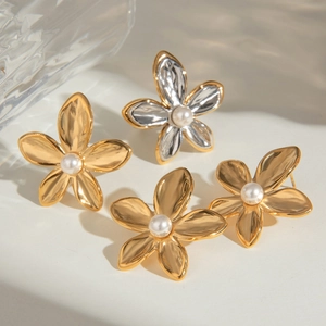 Detailed shot of gold and silver flower stud earrings with elegant pearl center inlay