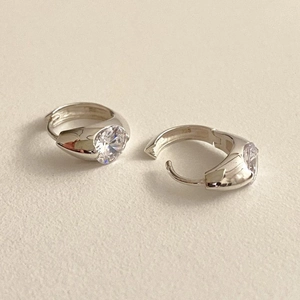 Detailed close-up of 925 sterling silver hoop earrings with clear round zirconia stones