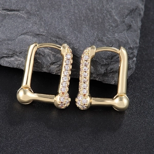 Luxurious gold geometric U-shaped earrings with micro-set zircons on dark rock background