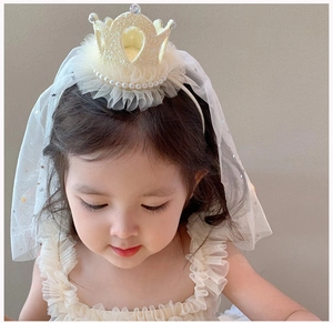 Detailed view of girls princess headband with gold glitter crown and soft white tulle veil