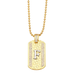 Detailed macro view of gold and silver rectangle pendant necklace with letter F and zircons