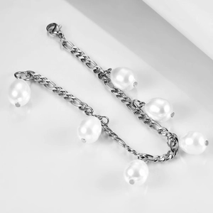 Detail view of 12mm Figaro chain bracelet with faux pearls in polished finish