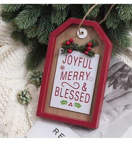 Detail of wooden Christmas door sign with Joyful Merry and Blessed text and pine needles